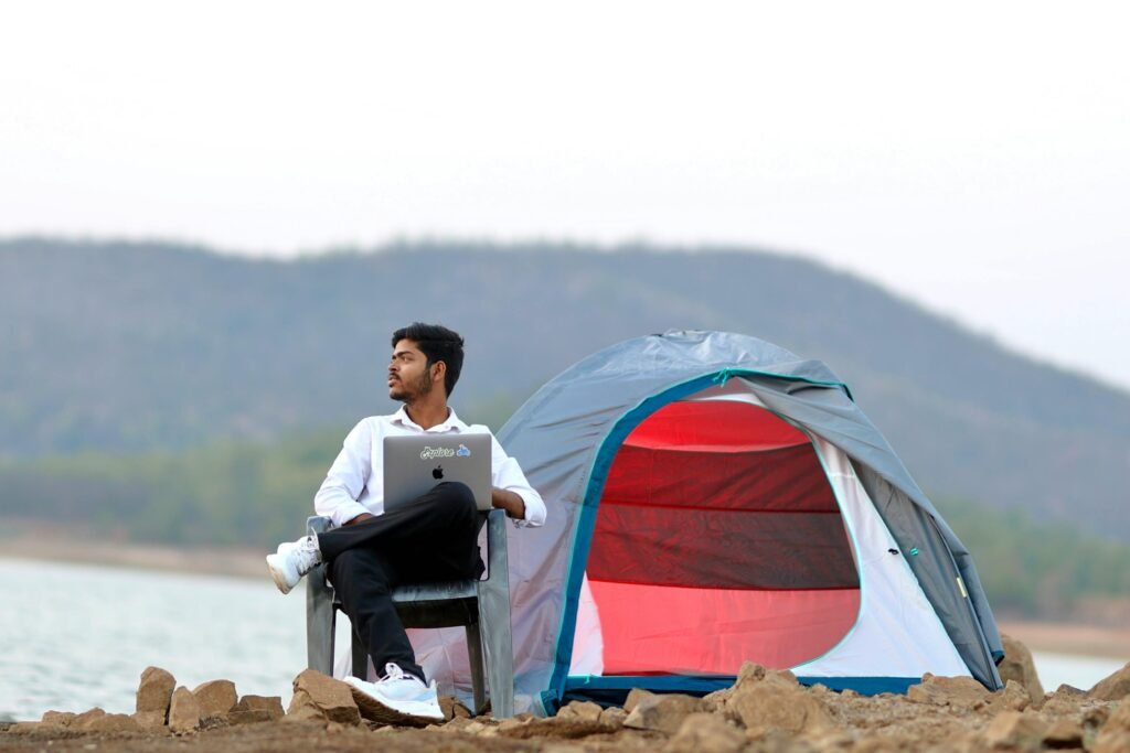 Professional using a laptop at a lakeside tent, representing the DeepL Review 2025 theme of precision and translation anywhere.