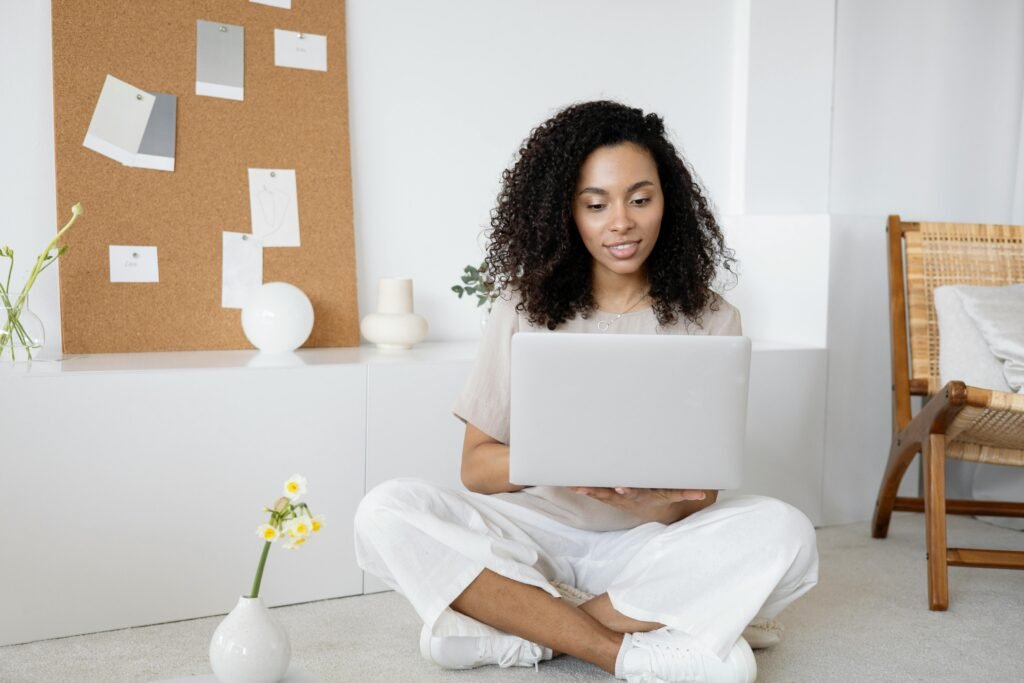 A woman focused on a laptop in a clean, minimalist home office, representing the cognitive ease and streamlined workflow of using simple AI writing tools like WriterBuddy.