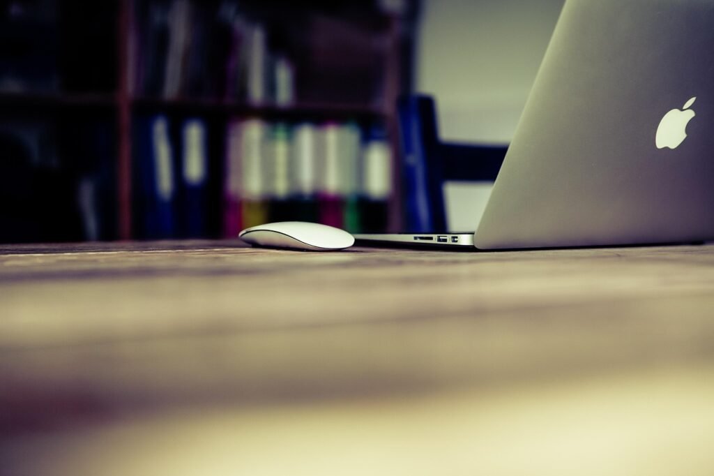 Minimalist writing workspace with a silver laptop open to the Jasper AI dashboard on a clean white desk with natural lighting.
