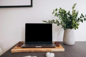 Modern researcher desk with laptop showing Thesify AI feedback for academic thesis writing.