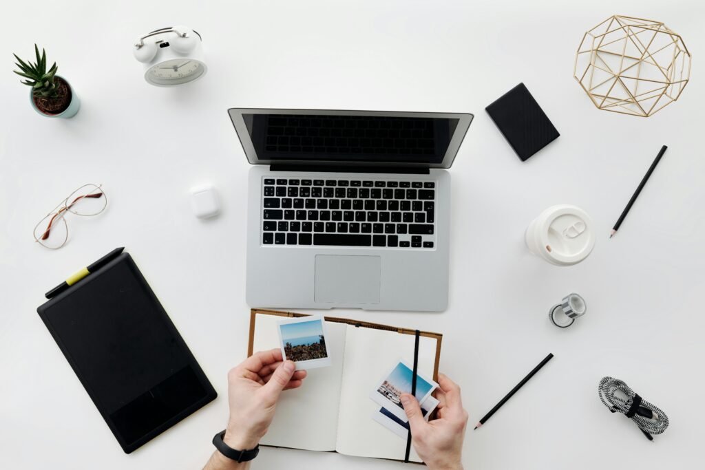 Student using laptop and notebook for AI-assisted thesis writing.