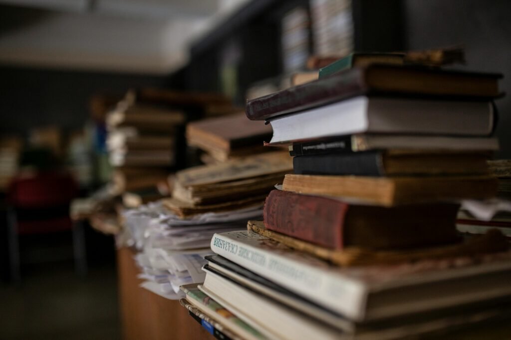 Stack of research books representing the volume of literature review sources for thesis writing.